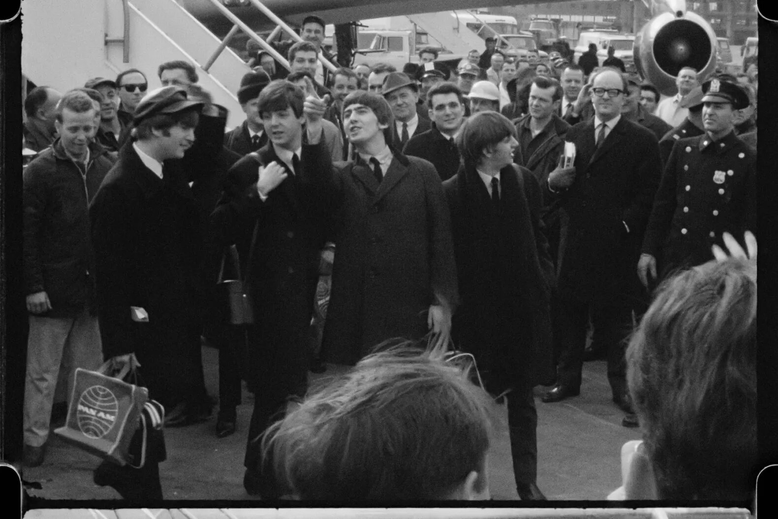 The Beatles departing from their plane to a sea of press in Disney's BEATLES '64