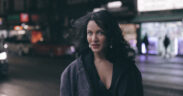 Anoushka Shankar wearing black jacket posing for photo outside on the street