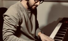 Composer and producer Rishabh Shah playing piano with headphones on