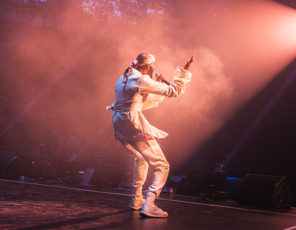 SVDP aka Shan Vincent de Paul in white jumping on stage in concert