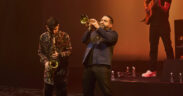 Ibrahim Maalouf playing trumpet on stage with an Indian saxophonist