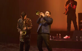 Ibrahim Maalouf playing trumpet on stage with an Indian saxophonist