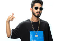 Talha Anjum wearing black tshirt with blue design, gold chain and black sunglasses