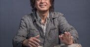 Tabla legend Zakir Hussain in a grey jacket playing tabla