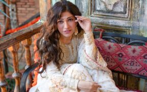 Tulsi Kumar wearing white dress seated with hand at head