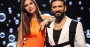 Simran Choudhary wearing orange dress with Amit Trivedi wearing black and white suit