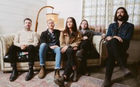 The Paper Kites band members sitting on a couch posing for a photo