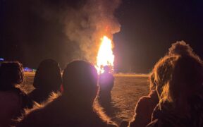 Attendees watch the burning of "The Chapel of Babel," art at Burning Man festival